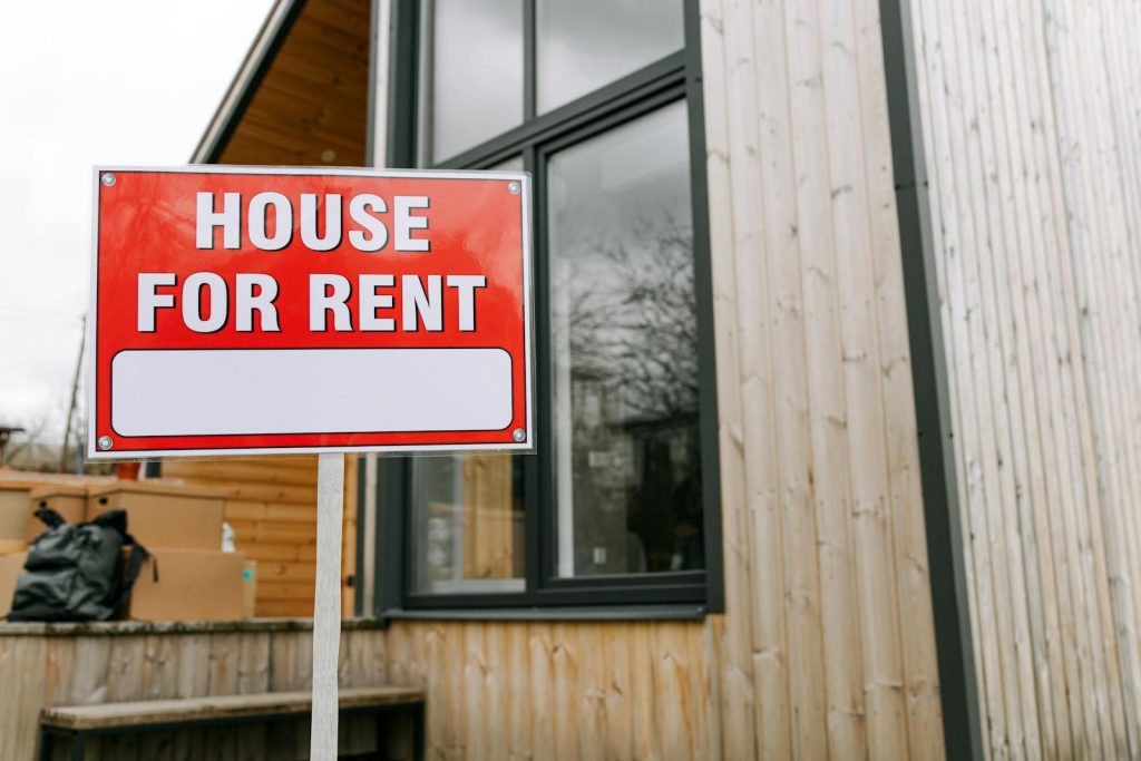Red House for Rent sign in front of modern wooden building